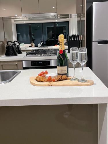 a bottle of wine and two wine glasses on a counter at Fantastic 3 Bedroom Apartment in Southbank in Melbourne
