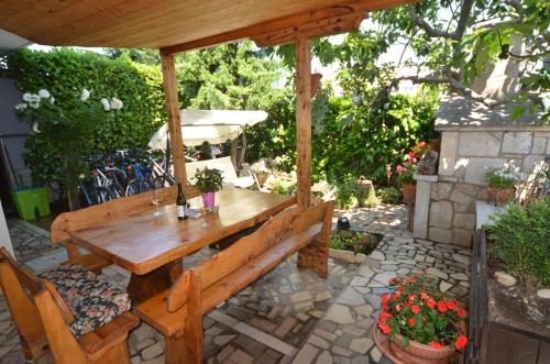 un tavolo in legno e una panca sotto un padiglione di Guesthouse Mila a Rovigno (Rovinj)