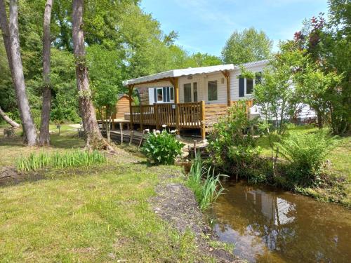 a cabin in the woods next to a river at Le Mill in Meilhan