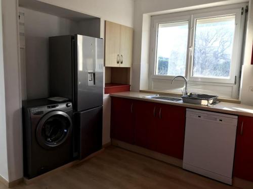 a kitchen with a refrigerator and a washing machine at Cocon familial dans le Pays Bigouden ! in Plonéour-Lanvern