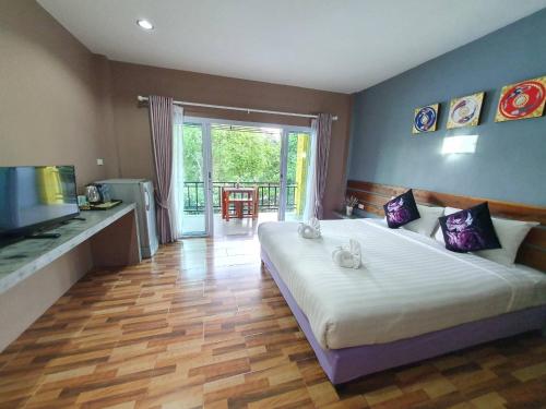 a bedroom with a large bed and a balcony at Greenery Resort Koh Tao in Koh Tao