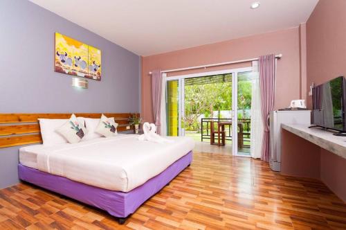 a bedroom with a large bed and a television at Greenery Resort Koh Tao in Koh Tao