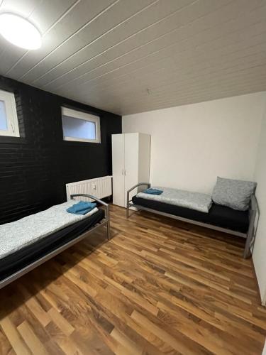 Habitación con 2 camas y suelo de madera. en Monteurapartment - Messeapartment bis zu 3 Personen, en Hannover
