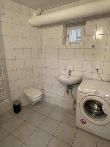 y baño con lavadora y lavamanos. en Monteurapartment - Messeapartment bis zu 3 Personen, en Hannover