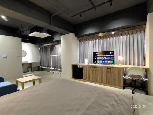 um quarto com uma cama e uma televisão de ecrã plano em 肆樓寓所 em Tainan