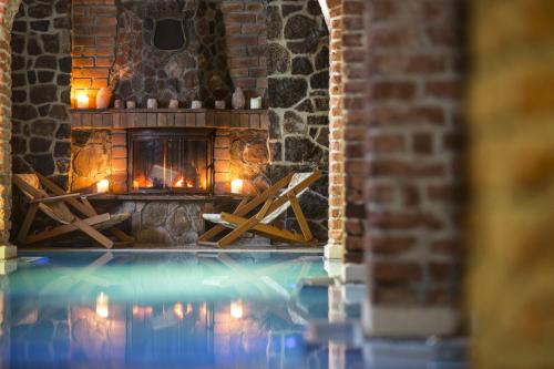 a swimming pool with a fireplace in a brick building at Willa Pod Zamkiem in Ryn