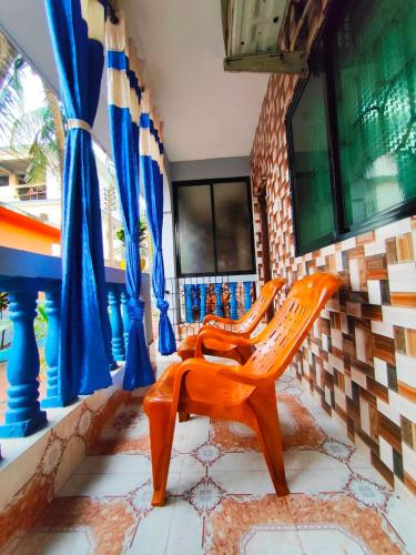 two wooden benches in a room with blue curtains at Yash-Deep - 100 meter Calangute Beach in Calangute