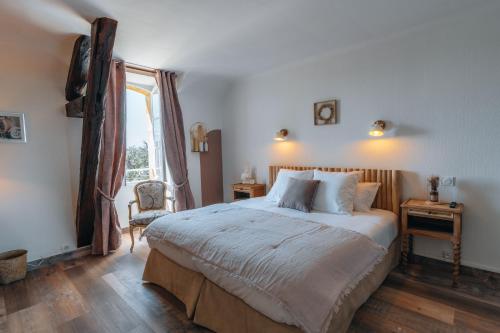 a bedroom with a large bed and a window at Hôtel l'Abbaye in Saint-Cyprien