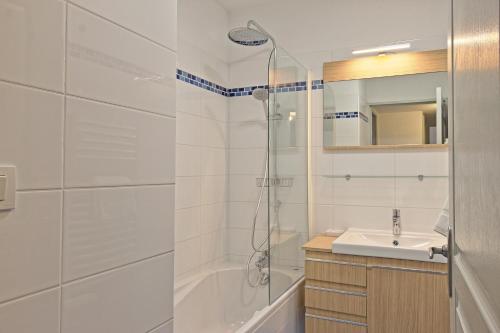 een witte badkamer met een douche en een wastafel bij L'Ecluse - Clim - Parking - Central in Nîmes