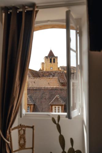a window with a view of a building at Hôtel l'Abbaye in Saint-Cyprien