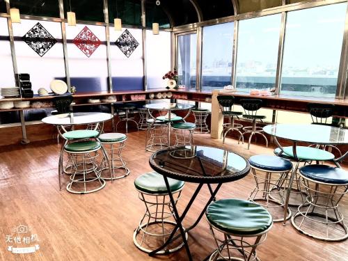 台南的住宿－藍天驛站商務旅館，餐厅设有桌子和凳子,位于带窗户的房间内