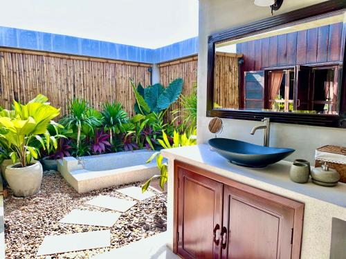 a bathroom with a sink and a tub in a yard at Chef Nak Luxury Homestay in Phnom Penh
