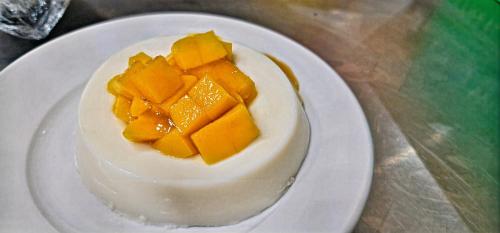 a white cake on a white plate on a table at Sempre Premier Inn - MACTAN AIRPORT HOTEL in Mactan