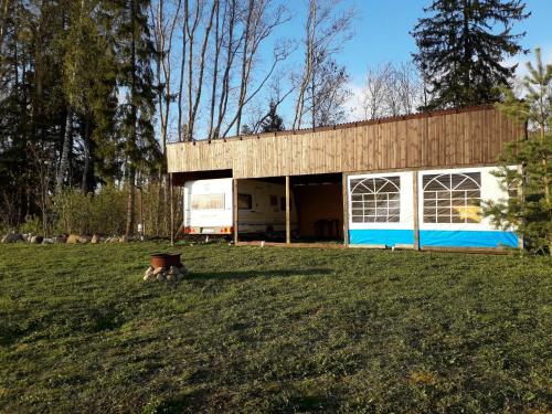 a house with a blue and white garage in a field at Rossu haagissuvila in Saksa