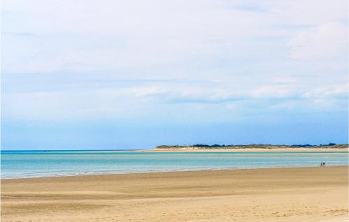 a beach with the ocean and a cloudy sky at Gorgeous Home In Creances-Plage in Créances