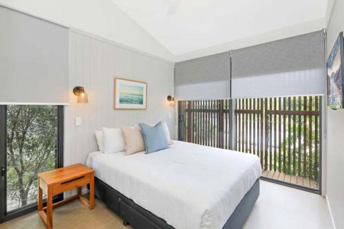a bedroom with a large bed and a window at Reflections Shaws Bay - Holiday Park in Ballina