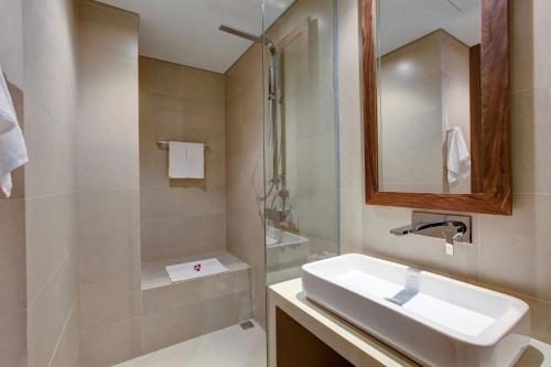 a bathroom with a sink and a shower and a mirror at Stunning Apartments Across My Khe Beach ! Rooftop Pool & Gym in Da Nang