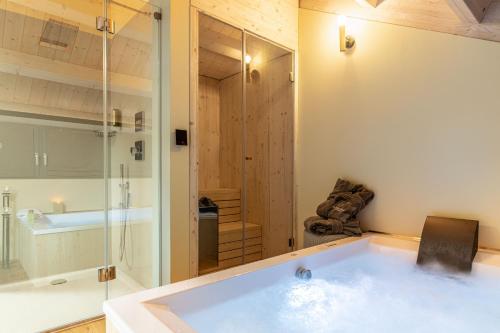 a bathroom with a tub and a glass shower at Agritur La Dolce Mela - Adults Only in Vezzano