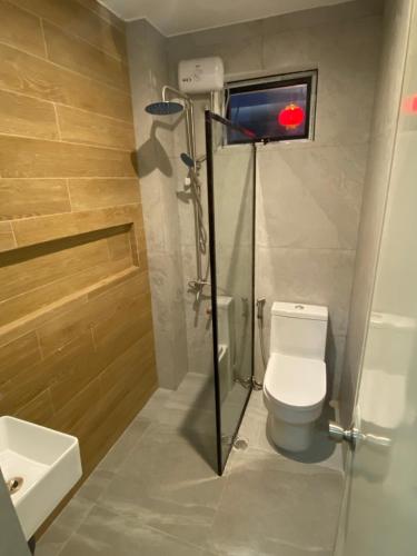 a bathroom with a shower and a toilet and a sink at Aurora Suites in Manila