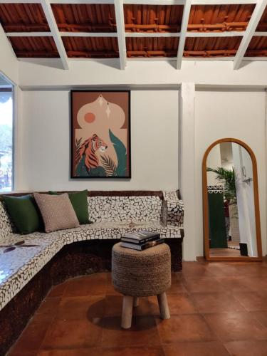 a living room with a couch and a table and a mirror at Olive Zip Calangute Mira by Embassy Group in Calangute