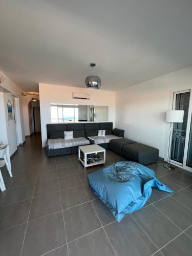 un salon avec un canapé et une table dans l'établissement Appart avec terrasse vue sur mer exceptionnelle, à LʼÎle-Rousse