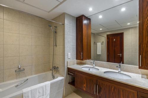 a bathroom with two sinks and a large mirror at Splendid Apartments with Burj Khalifa and Fountain View in Dubai
