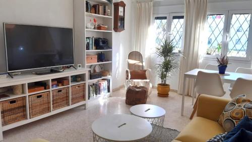 sala de estar con TV de pantalla plana y sofá en Apartamento Yerbabuena, en Sanlúcar de Barrameda