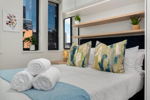 a bedroom with a bed with towels on it at The Carrington Aparthotel by Totalstay in Cape Town