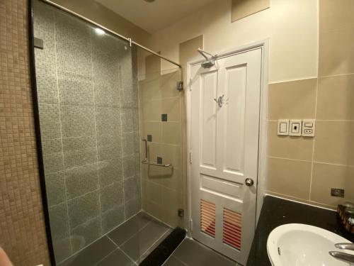 La salle de bains est pourvue d'une douche avec une porte en verre et d'un lavabo. dans l'établissement Phú Gia Hotel, à Hô-Chi-Minh-Ville