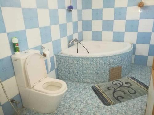 a bathroom with a toilet and a bath tub at Villa Fleurie : Belle Maison ensoleillée in Pointe aux Piments