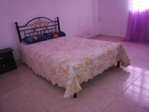 - une chambre avec un lit doté d'un couvre-lit blanc dans l'établissement Villa Fleurie : Belle Maison ensoleillée, à Pointe-aux-Piments
