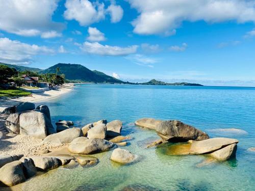 - une vue sur une plage avec des rochers dans l'eau dans l'établissement Beluga Boutique Hotel, à Lamai