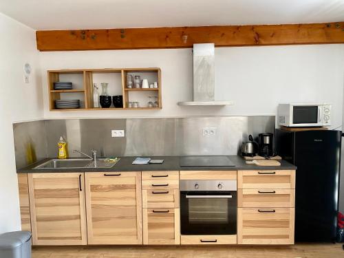 a kitchen with a sink and a stove at Appartement idéal pour été et hiver, situé au pied des pistes de ski et des sentiers de randonnée in Prémanon