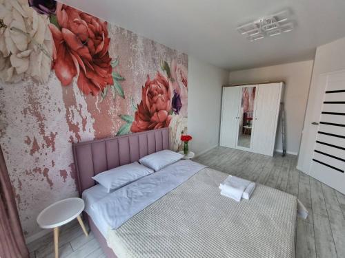 a bedroom with a bed and a painting on the wall at Dream town Apartaments біля залізничного вокзалу in Luts'k