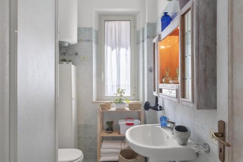 a bathroom with a sink and a toilet and a window at Casina di Marnie in Balestrate