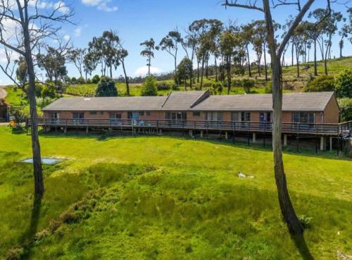 a large building with a green field and trees at Peaceful 3 bedroom villa with gaming room in Wallan