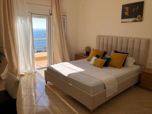 - une chambre avec un lit et une vue sur l'océan dans l'établissement Theona Apartments, à Saranda