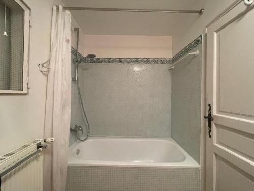 Appartement près de DOLE في Menotey: حمام مع حوض استحمام أبيض ودش
