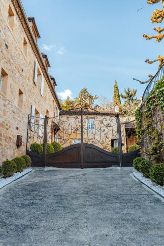 a large gate to a house with a driveway at Hôtel l'Abbaye in Saint-Cyprien