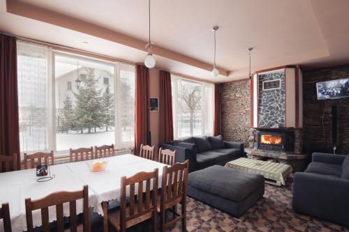 a living room with a table and a fireplace at Atanasovata Kashta in Govedartsi