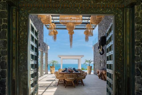 una sala da pranzo con tavolo, sedie e lampadario pendente di BLUE ELEPHANT Luxury Pool Villa Koh Samui by Blue Mountain Villas a Ko Samui