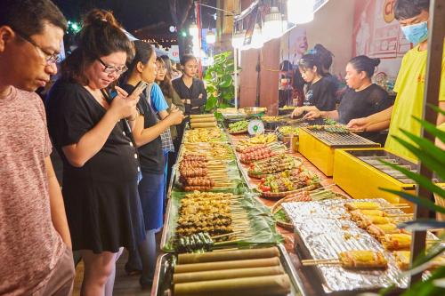 un grupo de personas de pie alrededor de un buffet de comida en Le Cactus Hotel Ha Long en Ha Long