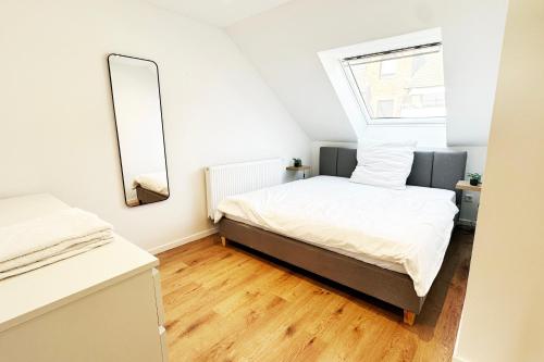 a small bedroom with a bed and a mirror at Suite-Apartment zentral in Krefeld mit hohen Decken in Krefeld
