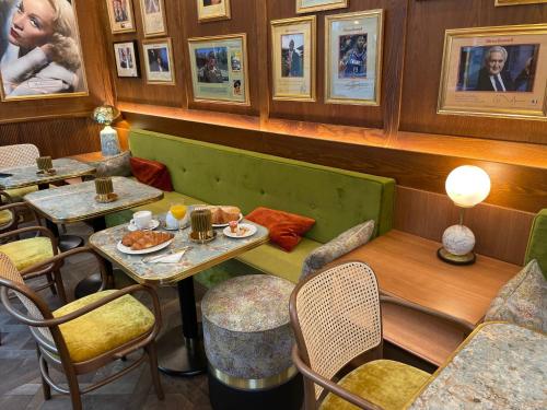 un restaurant avec des tables, des chaises et des photos sur le mur dans l'établissement Maison Kammerzell - Hotel & Restaurant, à Strasbourg