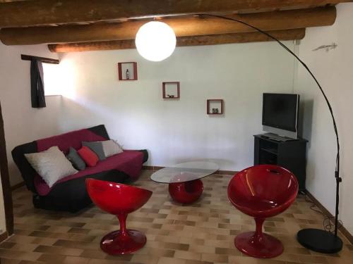 sala de estar con sofá rojo y sillas rojas en Ferme de Fonfroide Location à la semaine en La Motte-Chalançon