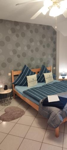 a bedroom with a bed with blue pillows on it at Pension Deerkemer Kuh in Dorn-Dürkheim