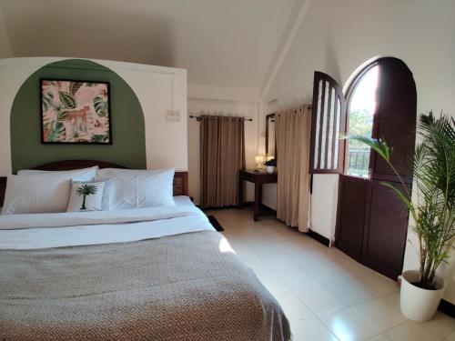 a hotel room with a bed and a window at Olive Zip Calangute Mira by Embassy Group in Calangute