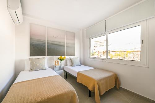 una habitación con dos camas y una ventana en New 2 bedroom beach and city center - Ruiz Vertedor by 10ToSea, en Fuengirola