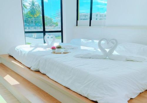 a white bed with two swans on top of it at Pangkor Better Life Cozy Studio-walking 2min to beach,1-4pax in Pangkor