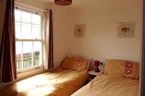 a bedroom with two beds next to a window at Parc Trethias in St Merryn